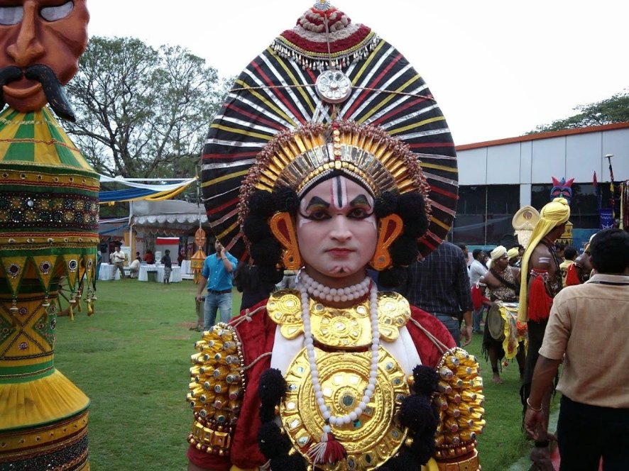 Yakshagana performer in traditional costume, showcasing vibrant makeup, elaborate headdress