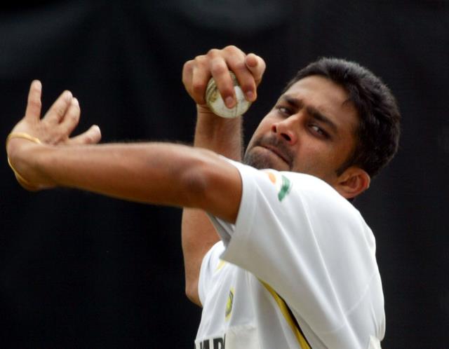 Anil Kumble in action, wearing the Indian cricket team's whites, preparing to deliver a leg-spin bowling during a Test match.