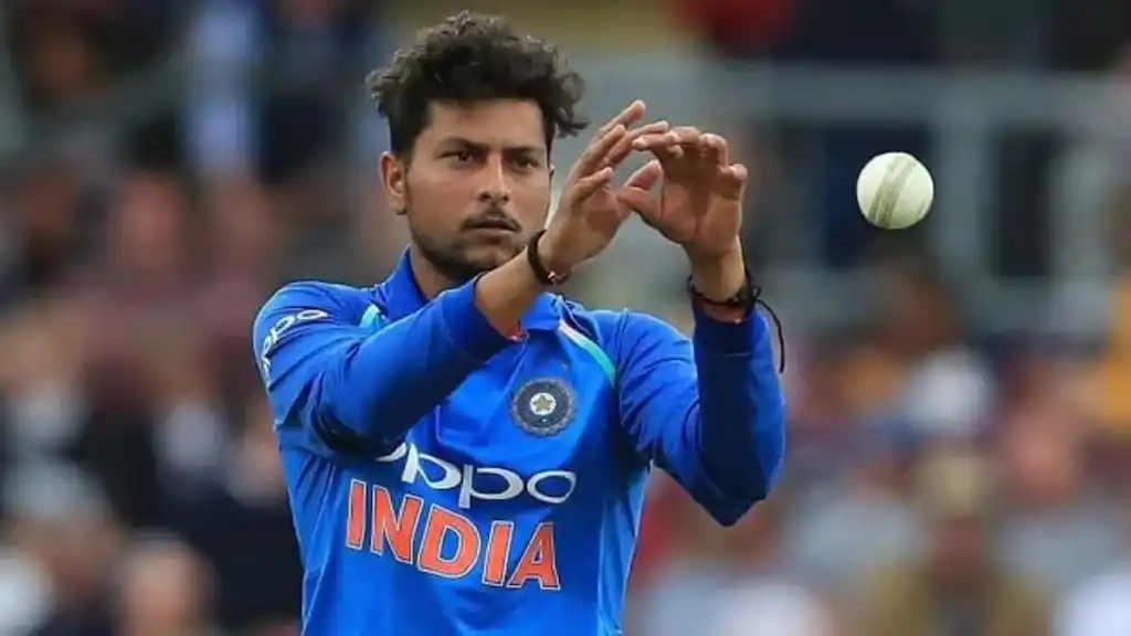 Kuldeep Yadav mid-delivery in a cricket match, showcasing his left-arm wrist-spin bowling technique in the Indian jersey.