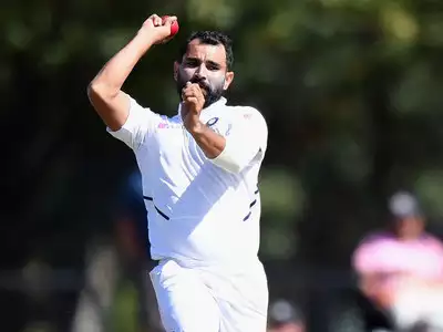 Mohammed Shami, wearing the Indian jersey, preparing to bowl a swing delivery with precision during a cricket match.