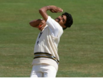 Kapil Dev, wearing a cricket jersey, standing on the field during a match, showcasing his iconic confident pose.