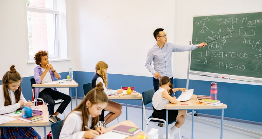 Teacher is teaching students maths on the board