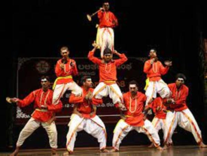 A group of performers in traditional attire performing Kamsale, a folk dance from Karnataka