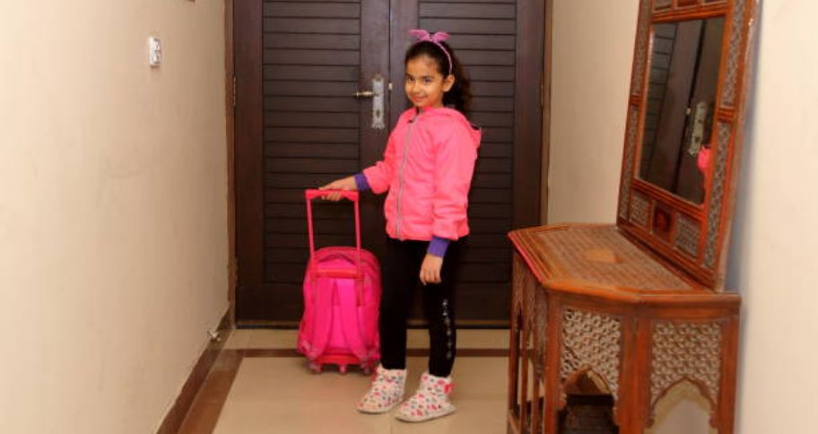 girl carrying trolley bag