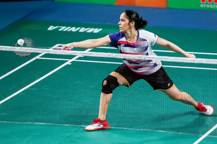 Saina Nehwal is intensely focused on the court, gripping her racket with precision. She made history as the first Indian woman to achieve a World No. 1 ranking and clinch an Olympic medal.