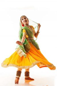 A Kathak dancer in a graceful pose, dressed in traditional attire, showcasing intricate footwork and expressive gestures.