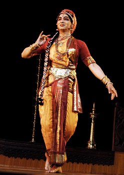 women performing Gollakalpam dance, forming a circle while swaying in unison with their hands raised.