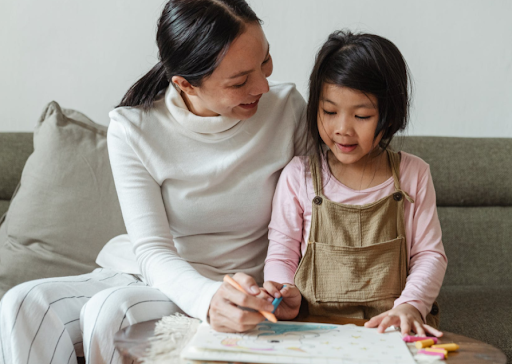 A young girl learning to draw and colour.