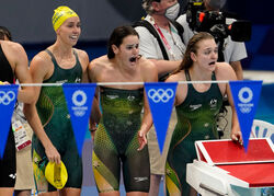 3 Australian women swimmers celebrating their team performance in the Olympics, showcasing their excitement and camaraderie